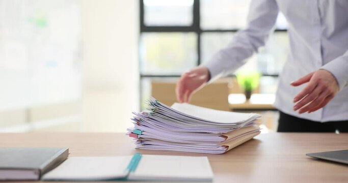 Intern takes stack of business documents from desk