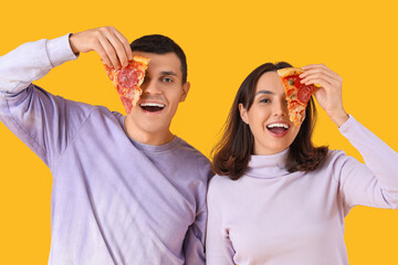 Young couple with tasty pepperoni pizza on color background
