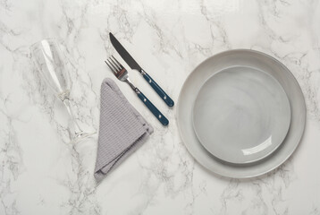 Plates, cutlery with towel on marble background. Table setting