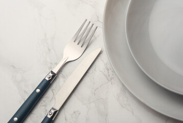 Plates with cutlery on marble background. Table setting
