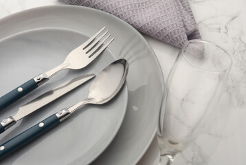 Plates, cutlery with towel on marble background. Table setting.