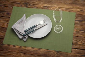 Set of dishes and cutlery for table setting on wooden background