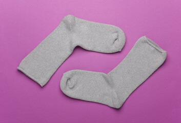 Pair of gray socks on a purple background