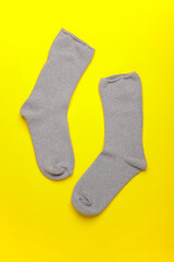 Pair of gray socks on a yellow background