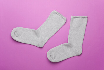 Pair of gray socks on a purple background