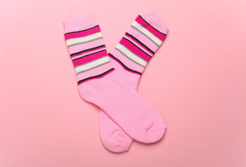 Pink socks on a pink background. Top view