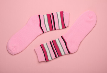 Pink socks on a pink background. Top view