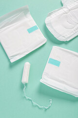 Menstrual pads with tampon on turquoise background