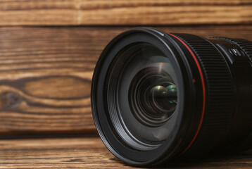 Professional lens on wooden background. Photographer's equipment