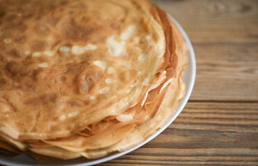 Stack of pancakes on a plate, wooden table