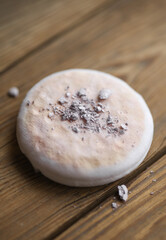 Makeup sponge with powder on a wooden background