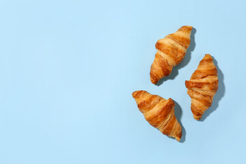 Tasty croissants on blue background