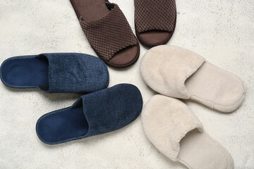 Three pairs of slippers on white grunge background. Top view