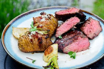 closeup grilled beef meat with vegetables and baked potatoe