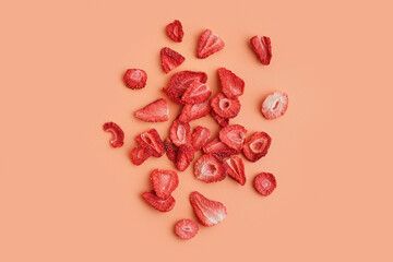 Tasty freeze-dried strawberries on orange background