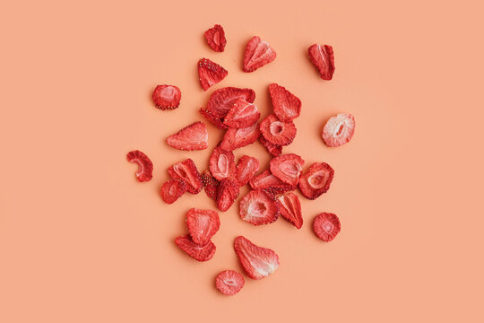 Tasty freeze-dried strawberries on orange background