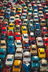 Fototapeta premium A crowded scene of miniature toy cars, tightly arranged to fill the entire frame. The cars come in various models and bright colors like red, blue, yellow, and green