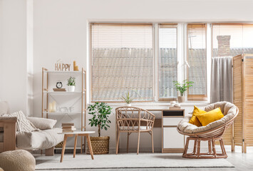 Interior of light living room with couch, armchair and tables