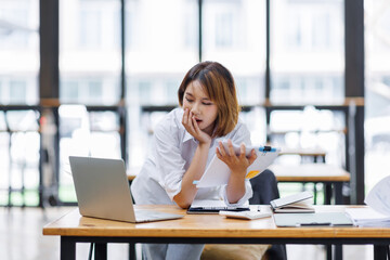 Portrait of happy asian female employee at computer