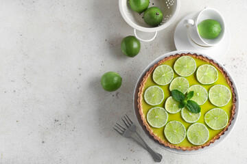 Stand of tasty lime tart with mint on white background