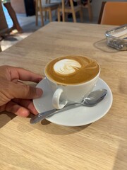 A Cup of Coffee With Latte Art on a Wooden Table in a Cafe
