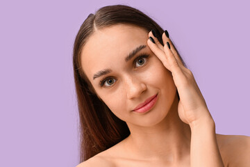 Fototapeta premium Young woman with beautiful eyebrows on lilac background