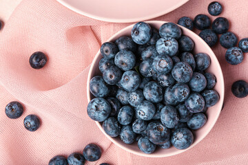 Bowl with sweet fresh blueberries on napkin, closeup
