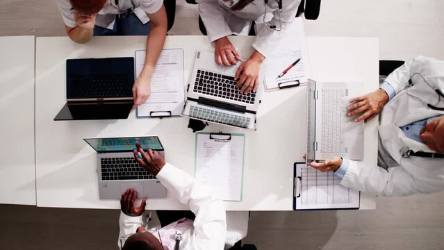 Medical Doctor Group Meeting At Desk