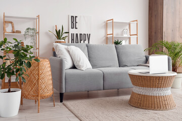 Interior of living room with sofa and laptop on rattan table