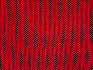 Red breathable porous poriferous material for air ventilation with holes. Sportswear material nylon texture.