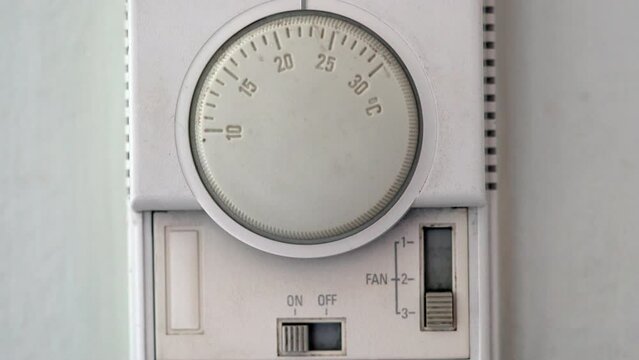 A white thermostat to control temperature of air condition
