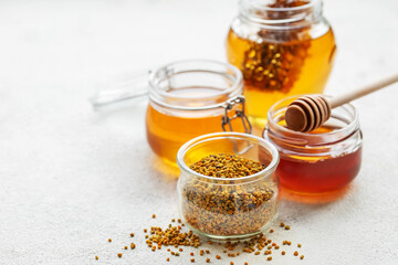 Raw organic bee pollen and honey in jars.