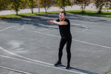 Bearded man doing exercises outdoors. 