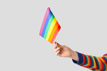 Female hand with LGBT flag on grey background