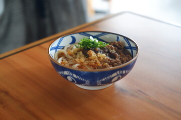 japan style noodles with beef and vegetables on wooden table.