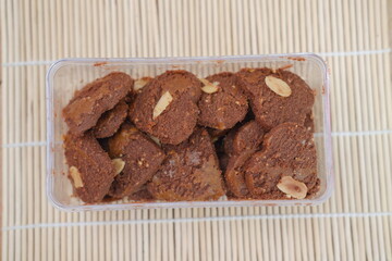 Dark chocolate cookies home made stacked with chocolate chips on a wooden background