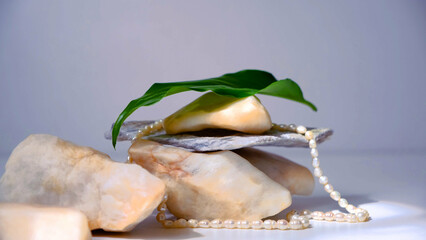 Template, marble podium with stone and plants, jewelry pearls. empty space. Pastel background. Background for design. Space for presentation product. Pedestal cosmetics fashion presentation