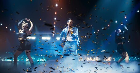 Young K-Pop Singer in a Stylish Blue Outfit Performing a Concert with Show Girls on a Festival Stage Surrounded by Falling Confetti. His Charisma and Lyrics Electrify the Music Fans in Crowded Arena