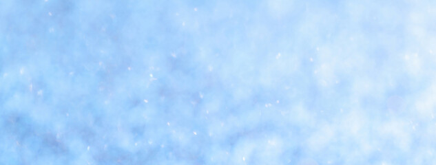 Blurred light blue background with circle sparkling lights. Shiny brilliant glittery bokeh of christmas garland.