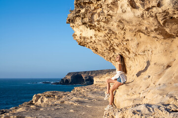 Woman Enjoying a Serene Sunset on Ajuys Rocky Coastline