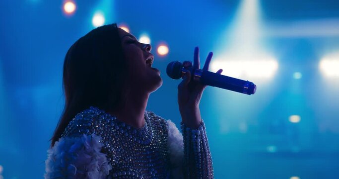 Portrait of a Beautiful Young Woman Singing a Song at a Music Contest. Cinematic Neon Spotlights Illuminates the Star, Her Empowering Stage Presence and Lyrics Electrify the Stage