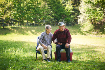 公園で記念写真を撮る高齢の日本人夫婦