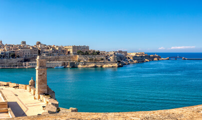 Fototapeta premium Fort St. Angelo, symbol of Malta's resilience, majestic stone walls, silent witness to rich history. Port in Birgu. View to Fort Saint Elmo. Cultural heritage of Malta