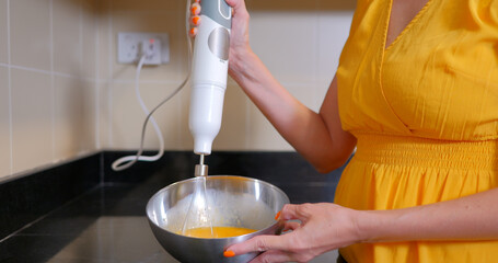 Woman whips eggs for dough with a whisk