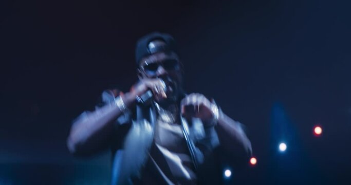 Music Contest: Portrait of a Hip Hop Music Artist Performing a Hit Song on Stage in Front of a Sold-Out Audience. His Charismatic Stage Presence and Lyrics Electrify the Diverse Music Fans
