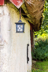 Lantern hanging by a wall at an old barn