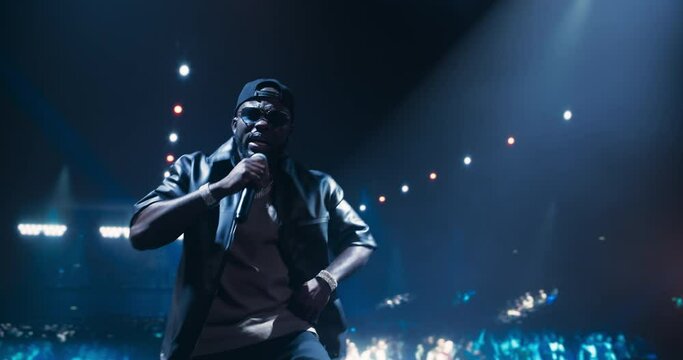 Male Rapper Lights Up the Night With a Creative Performance. Music Artist Enthusiastically Dancing on Stage, Creating an Urban and Underground Atmosphere on Stage with His Stylish Outfit