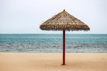 Straw umbrella on the beach in Doha on a cloudy day
