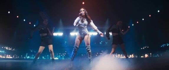 Talent Show Performance: Portrait of a Young Female Pop Singer on a Stage with Colorful Neon Lighting. Musician Singing a Powerful Solo, Translating Her Heartfelt Emotions into Music. Anamorphic Shot
