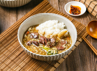Beef and egg risotto with chilli sauce, onion, wooden spoon, and chopsticks served in dish isolated on mat side view of taiwanese food